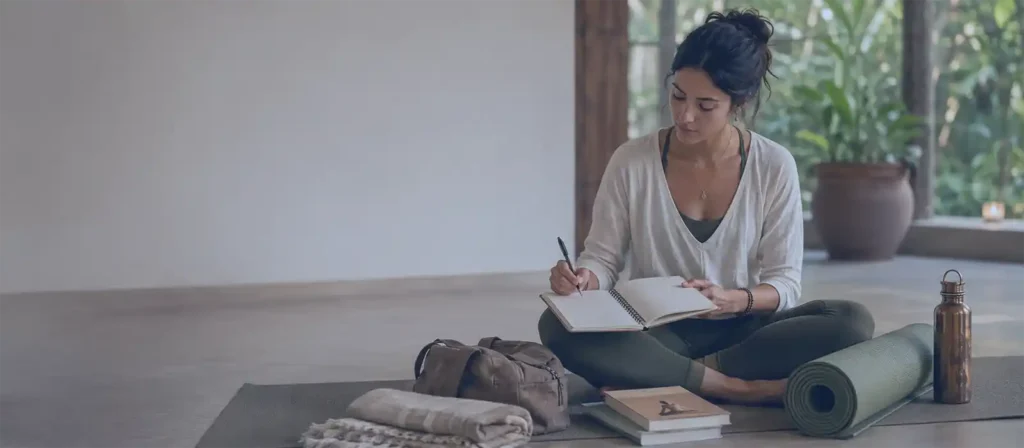 How to Prepare for Yoga Teacher Training Yoga & Meditation Blog How to Prepare for Yoga Teacher Training :Student preparing for Yoga Teacher Training by reviewing notes with a yoga mat, journal, books, and water bottle in a calm yoga space.